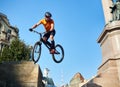 Young man performing a radical mountain bike jumps in old town