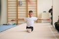 The young man performs gymnastic exercises in the gym.