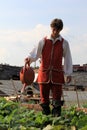 Young man in period dress, watering garrison garden,Fort William Henry,Lake George,New York,2015