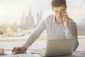 Young man on phone using laptop Royalty Free Stock Photo