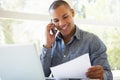 Young Man On Phone Using Laptop At Home Royalty Free Stock Photo