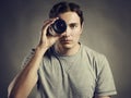 Young man photographer holding a lens in his eye