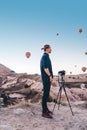 Young man photographer making pictures of air balloons at sunrise time in Cappadocia Royalty Free Stock Photo