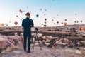 Young man photographer making pictures of air balloons at sunrise time in Cappadocia Royalty Free Stock Photo