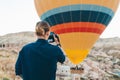 Young man photographer making pictures of air balloons at sunrise time in Cappadocia Royalty Free Stock Photo