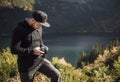 Young  man photographer taking photographs with digital camera in a mountains Royalty Free Stock Photo