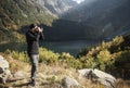 Young  man photographer taking photographs with digital camera in a mountains Royalty Free Stock Photo