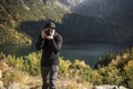 Young  man photographer taking photographs with digital camera in a mountains Royalty Free Stock Photo