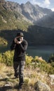 Young  man photographer taking photographs with digital camera in a mountains Royalty Free Stock Photo