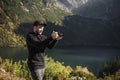 Young  man photographer taking photographs with digital camera in a mountains Royalty Free Stock Photo