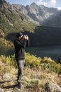 Young  man photographer taking photographs with digital camera in a mountains Royalty Free Stock Photo