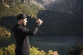 Young  man photographer taking photographs with digital camera in a mountains Royalty Free Stock Photo