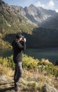 Young  man photographer taking photographs with digital camera in a mountains Royalty Free Stock Photo