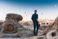 Young man photographer on vacation in Turkey Cappadocia looking at the air balloons during Sunrise at Kapadokya