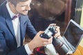 Young man photographer working at cafe, using dslr camera