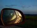 Young man photographing sunset from the car on full speed