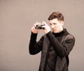 The young man photographs model the vintage camera at a wall