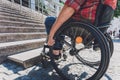 Young man with a physical disability in a wheelchair in front of the stairs Royalty Free Stock Photo