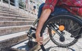 Young man with a physical disability who uses wheelchair in front of the stairs Royalty Free Stock Photo