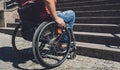Young man with a physical disability who uses wheelchair in front of the stairs Royalty Free Stock Photo