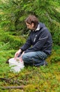 Young man picking lingonberries Royalty Free Stock Photo