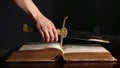 Young man picks up sword near bible