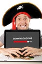 Young man in pirate costume with Computer laptop downloading files copyright violation Royalty Free Stock Photo