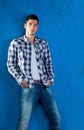 Young man with plaid shirt denim jeans in blue