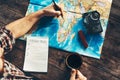 Young Man Is Planning Vacation Travel With Map, Top View. He Drinks Coffee And Marks Royalty Free Stock Photo