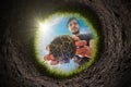 Young man is planting the plant in the garden. View from inside of hole in soil. Royalty Free Stock Photo