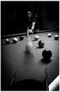 Young glasses man play billiard game (black and wh