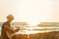 Young man play guitar on the beach and enjoy in sunset