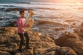 Young man play the trumpet on rocky sea coast during surf. Royalty Free Stock Photo