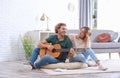 Young man playing acoustic guitar for his girlfriend Royalty Free Stock Photo