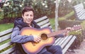 Young man playing on acoustic guitar outdoor Royalty Free Stock Photo