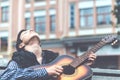 Young man playing on acoustic guitar outdoor Royalty Free Stock Photo