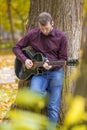 Young man playing acoustic guitar outdoors Royalty Free Stock Photo