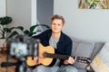 Young man playing acoustic guitar and recording music video for his social networks. Amatuer musician create content at Royalty Free Stock Photo