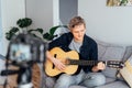 Young man playing acoustic guitar and recording music video for his social networks. Amatuer musician create content at Royalty Free Stock Photo
