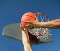 Young man playing basketball with friend against blue sky Royalty Free Stock Photo