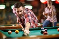 Young man playing billiard in club