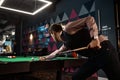 Young man playing billiard at night club