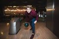 Young man playing bowling with a blue ball for bowling. A man throws a bullet on a stick. Royalty Free Stock Photo