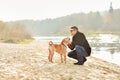 Young man playing with dog near the river