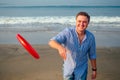 Young man playing flying disk on the beach in the morning Royalty Free Stock Photo