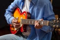 Young man playing guitar, close up view, dark background Royalty Free Stock Photo