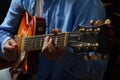 Young man playing guitar, close up view, dark background Royalty Free Stock Photo