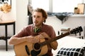 Young man playing guitar at home Royalty Free Stock Photo