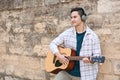Young man playing guitar outdoors Royalty Free Stock Photo