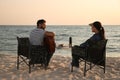 Young man playing guitar to his beloved girlfriend on beach. Camping season Royalty Free Stock Photo